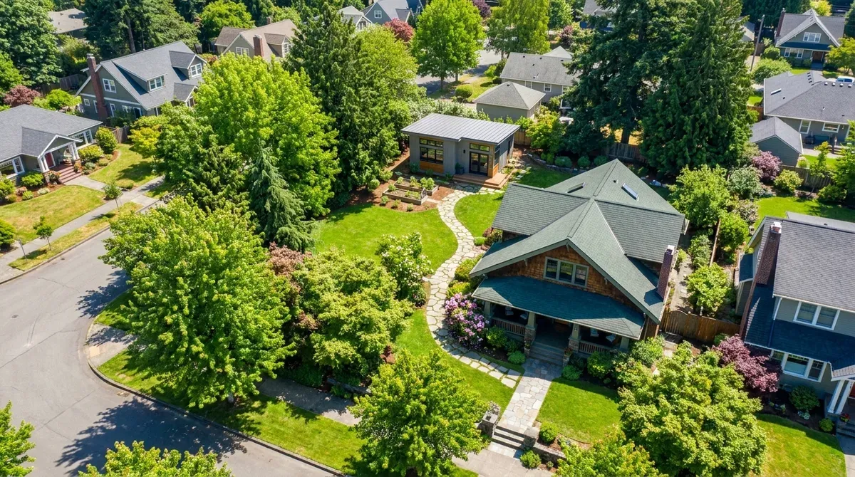 An aerial view of a property with a main house and a new backyard DADU adding value